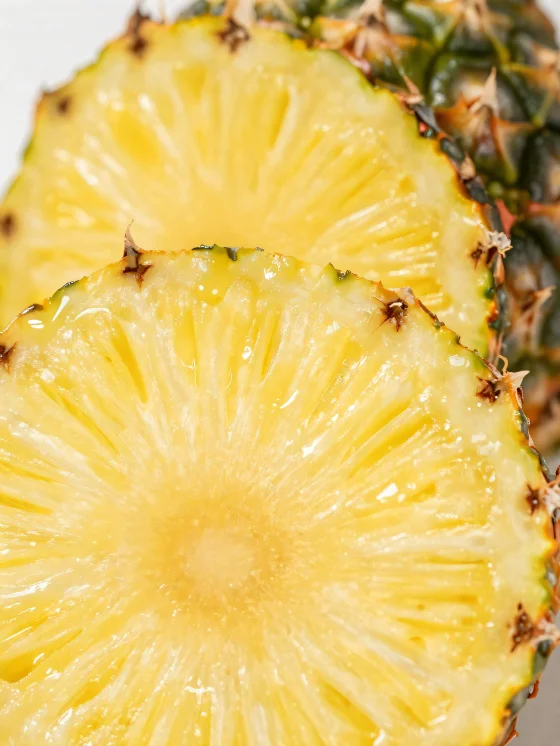 Fresh sliced pineapple on a rustic wooden table