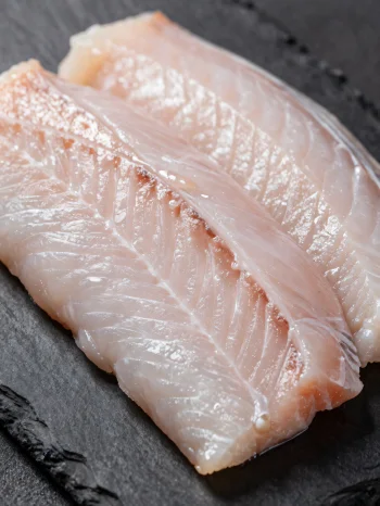 Fresh eel fillets with spices on a wooden chopping board