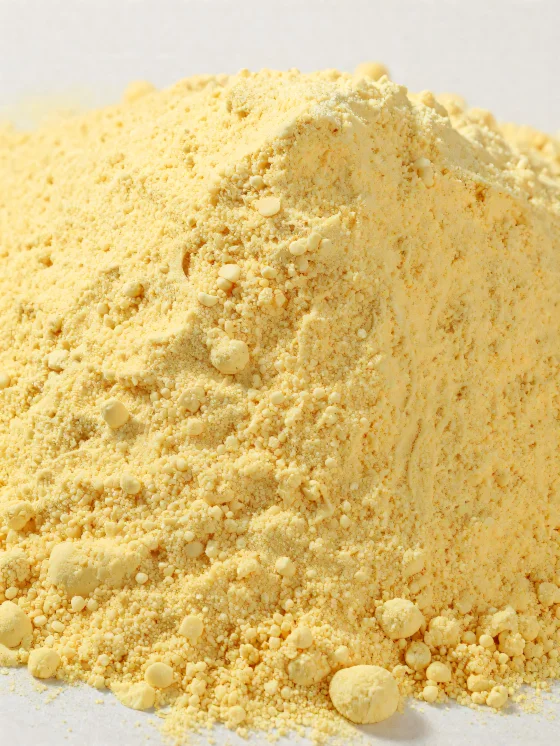 Maize flour in a ceramic bowl, yellow powdery flour on a wooden surface