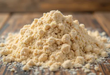 Wholemeal flour in a rustic bowl scattered on a wooden surface