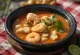 Moqueca with palm oil, fish and prawns in rich coconut milk sauce, sprinkled with coriander