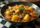 Sambar with mixed vegetables served alongside rice and vegetable side dish
