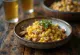 Mexican corn salad with walnuts, feta cheese and lime wedges