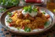 Ghuzi with yoghurt, served with spiced meat and fresh coriander