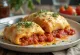 Stromboli with tomato sauce served, rich tomato sauce and melted mozzarella on top, crispy outside and soft inside.