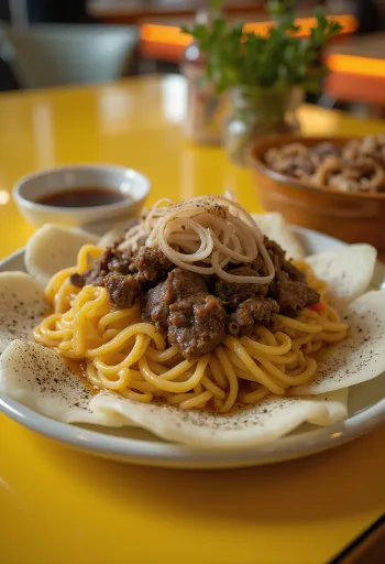 Beshbarmak with noodles, rich meat dish served with fine fried onions
