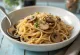 Pastel Tutup served with mushrooms and glass noodles, sprinkled with sesame seeds