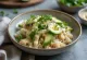 Tahini poké with fresh vegetables on a bed of rice, garnished with fresh coriander and lime juice.