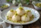Rasgulla decorated with pistachios, served on an elegant plate.