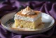 Classic tres leches slice, milk-soaked sponge on a white plate